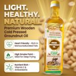 Seraphic Sun wooden cold pressed virgin groundnut oil ki bottle, jiske pas table par freshly bane samose, chakli aur namkeen rakhe hain.
